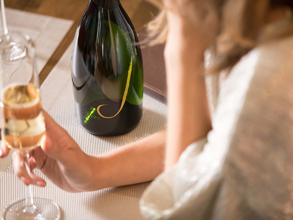 Person enjoying a glass of white wine from J Vineyards