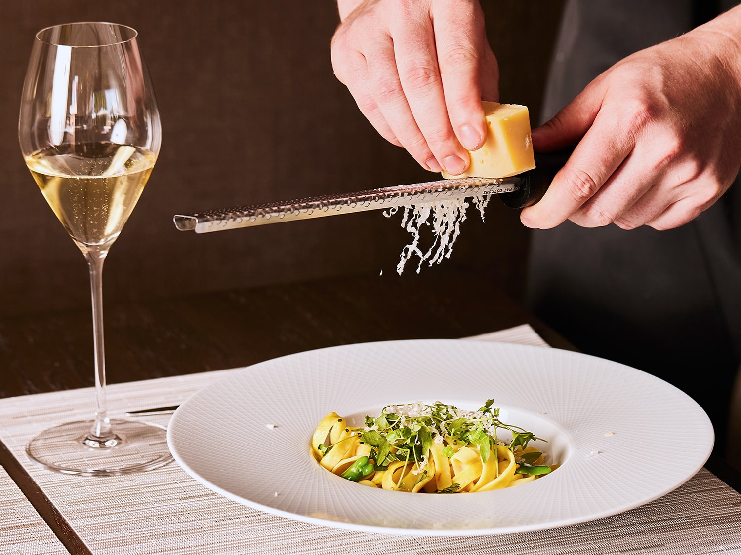 Cheese being grated over plate of food