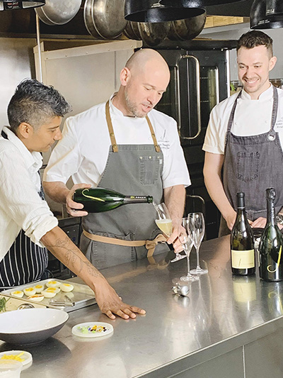 Chefs toasting with glasses of wine in the kitchen