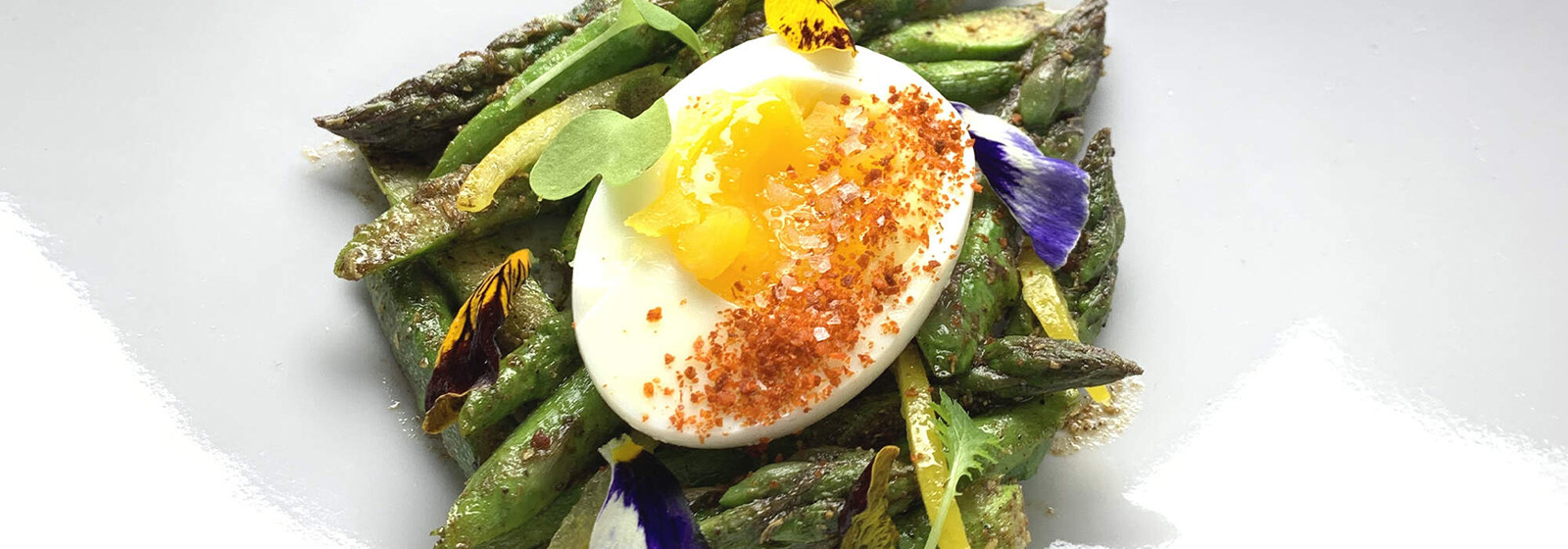 Hard boiled egg on a bed of asparagus
