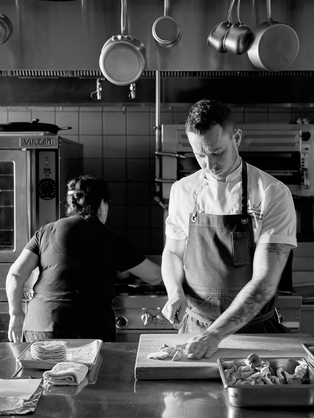 Two people preparing food in a kitchen.