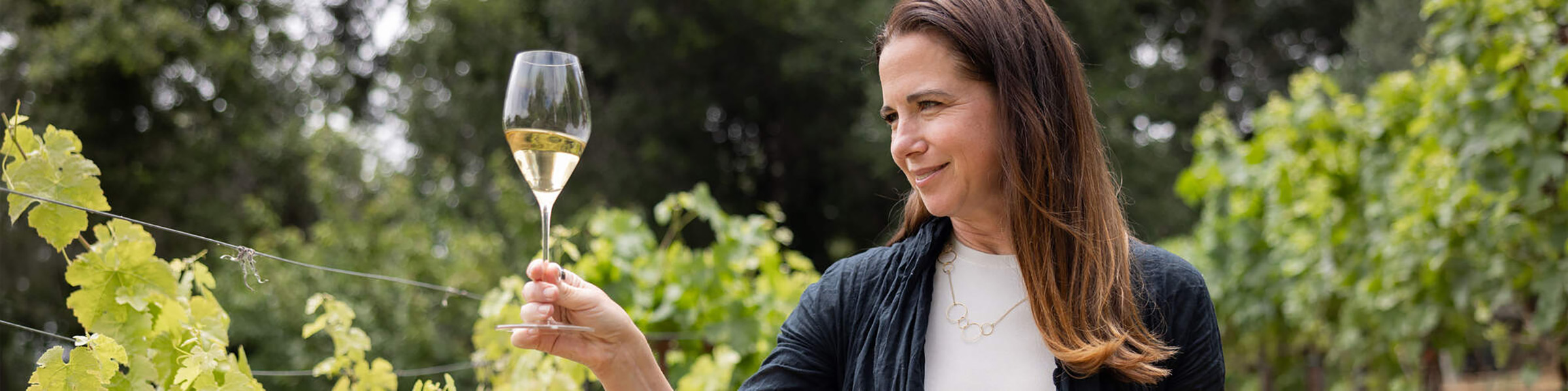 Winemaker, Nicole Hitchcock holding a glass of white white.