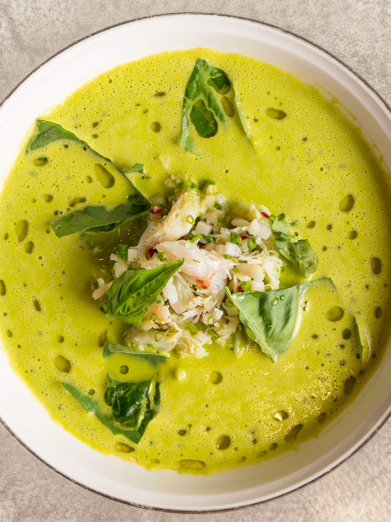 close up image of summer corn soup and Dungeness Crab in a bowl.